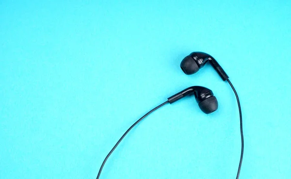 Black headphones on turquoise background