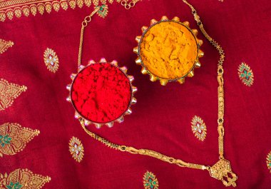 Mangalsutra or Golden Necklace to wear by a married hindu women, arranged with traditional saree with haldi, kumkum and grain rice on plate. Indian Traditional Jewellery.