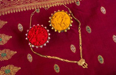 Mangalsutra or Golden Necklace to wear by a married hindu women, arranged with traditional saree with haldi, kumkum and grain rice on plate. Indian Traditional Jewellery.