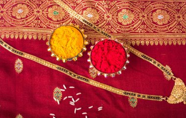 Mangalsutra or Golden Necklace to wear by a married hindu women, arranged with traditional saree with haldi, kumkum and grain rice on plate. Indian Traditional Jewellery.