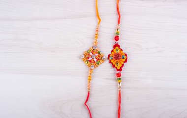Raksha Bandhan festivali konsepti renkli arka planda ayrıntıları gösteren tasarımcı Rakhi veya bileklik bandını gösteriyor. Kardeşler ve Kız Kardeşler arasındaki aşkın sembolü. Seçici odak.