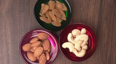 Variety mix of dried fruits and nuts in bowls on wooden background. Concept of Healthy fitness super food