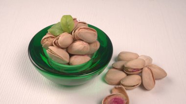 Pistachios in bowl on white background