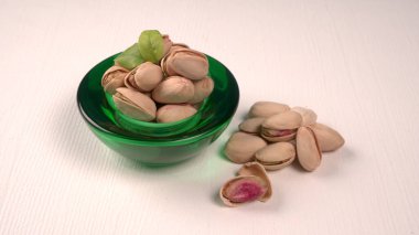 Pistachios in bowl on white background