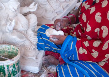Indian woman making Ganesha Hindu statue