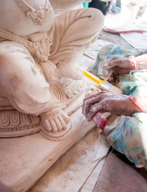 Indian woman making Ganesha Hindu statue