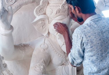 Indian man making Ganesha Hindu statue