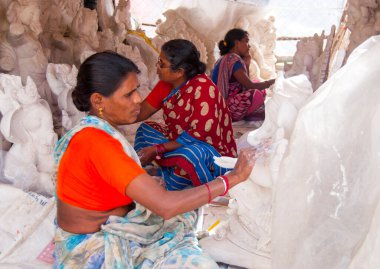 Indian women making Ganesha Hindu statue