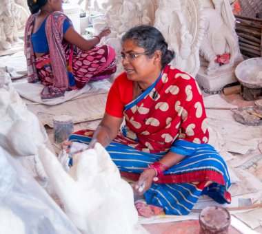 Indian women making Ganesha Hindu statue