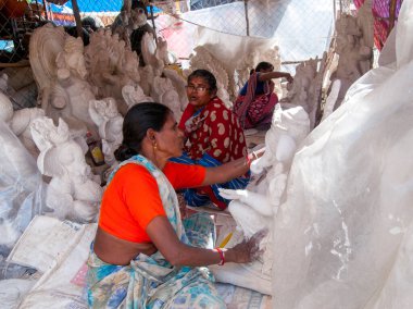 Indian women making Ganesha Hindu statue