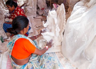 Indian women making Ganesha Hindu statue