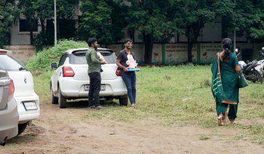 Men with Hindu statues near car