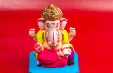 Kırmızı arkaplanda Ganesha Hindu heykeli