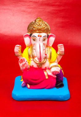 Kırmızı arkaplanda Ganesha Hindu heykeli