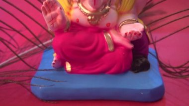 Kırmızı arka planda tavus kuşu tüyleri olan Ganesha Hindu heykeli