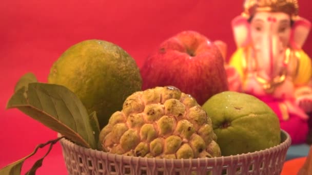 ガネーシャ ヒンドゥ教の像と赤い背景の果物とボウル — ストック動画