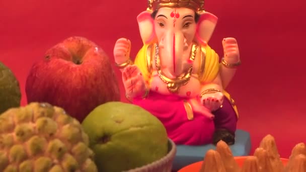 Ganesha Ινδουιστικό Άγαλμα Και Μπολ Φρούτα Κόκκινο Φόντο — Αρχείο Βίντεο