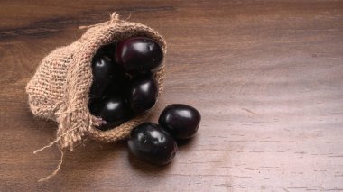 Tahta zemin üzerinde çuval olan erikler.