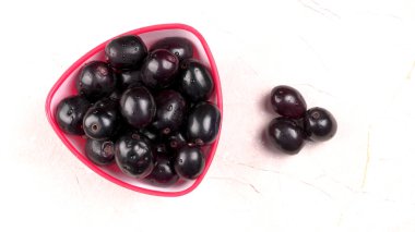 Tatlı erikler mermer arka planda kasede