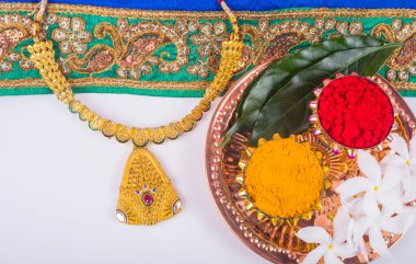 Mangalsutra ya da altın kolye evli Hindu kadınlar tarafından giyilir, haldi ve kumkum ile düzenlenir..