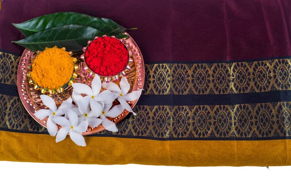 Yapraklar ve çiçekler, haldi ve kumkum ile sıralanmış..