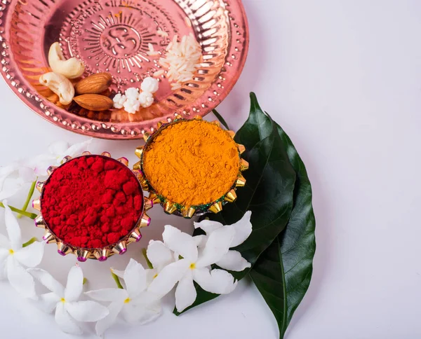 Beautifully Decoration for festival celebration to worship, haldi or turmeric powder and kumkum, flowers with leaves.Copy space.