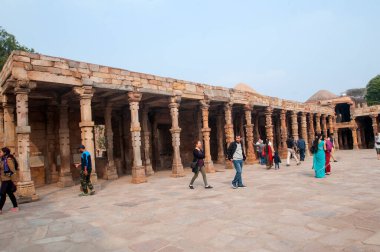 DELHI, Hindistan - 23 Şubat 2018: Kutub Minar 'ı ziyaret eden kimliği belirsiz kişiler, Hindistan' ın en uzun minaresi bir mermer ve kırmızı kumtaşı kulesidir. 