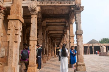 DELHI, Hindistan - 23 Şubat 2018: Kutub Minar 'ı ziyaret eden kimliği belirsiz kişiler, Hindistan' ın en uzun minaresi bir mermer ve kırmızı kumtaşı kulesidir. 