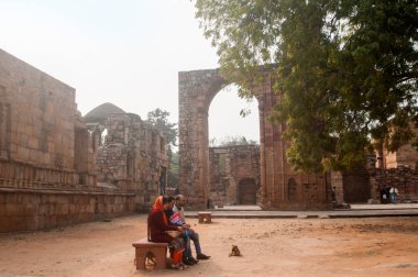 DELHI, INDIA - 23 Şubat 2018: Kutub Minar 'daki tanımlanamayan turist, Hindistan' ın en uzun minaresi bir mermer ve kırmızı kumtaşı kulesidir. UNESCO Dünya Mirası Alanı
