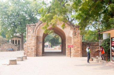 DELHI, Hindistan - 23 Şubat 2018: Kutub Minar 'ı ziyaret eden kimliği belirsiz kişiler, Hindistan' ın en uzun minaresi bir mermer ve kırmızı kumtaşı kulesidir. 