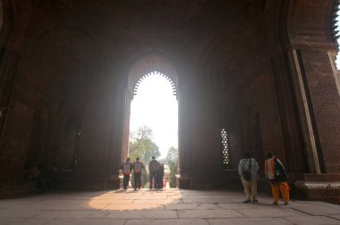 DELHI, Hindistan - 23 Şubat 2018: Kutub Minar 'ı ziyaret eden kimliği belirsiz kişiler, Hindistan' ın en uzun minaresi bir mermer ve kırmızı kumtaşı kulesidir. 