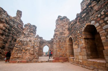 DELHI, Hindistan - 23 Şubat 2018: Kutub Minar 'ı ziyaret eden kimliği belirsiz kişiler, Hindistan' ın en uzun minaresi bir mermer ve kırmızı kumtaşı kulesidir. 