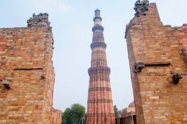 DELHI, Hindistan - 23 Şubat 2018: Kutub Minar 'ı ziyaret eden kimliği belirsiz kişiler, Hindistan' ın en uzun minaresi bir mermer ve kırmızı kumtaşı kulesidir.  