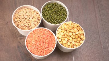 Ahşap arka planda pişmemiş nabız, tahıl ve tohumlar.