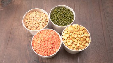 Ahşap arka planda pişmemiş nabız, tahıl ve tohumlar.