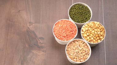 Ahşap arka planda pişmemiş nabız, tahıl ve tohumlar.