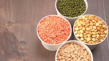 Ahşap arka planda pişmemiş nabız, tahıl ve tohumlar.