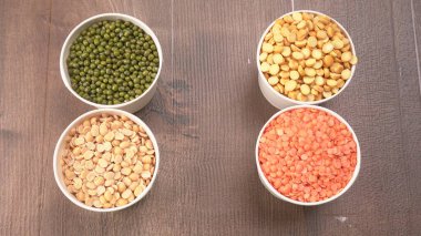 Ahşap arka planda pişmemiş nabız, tahıl ve tohumlar.