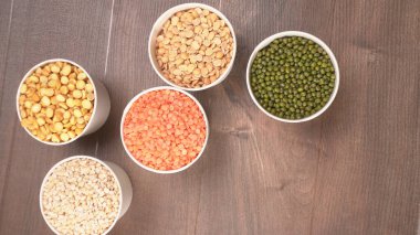 Ahşap arka planda pişmemiş nabız, tahıl ve tohumlar.