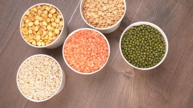 Ahşap arka planda pişmemiş nabız, tahıl ve tohumlar.