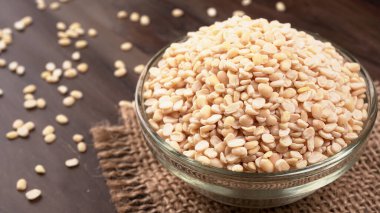 Çuvalda pişmemiş bezelyeler ve ahşap arka plan..