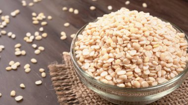 Çuvalda pişmemiş bezelyeler ve ahşap arka plan..