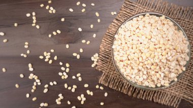 Çuvalda pişmemiş bezelyeler ve ahşap arka plan..