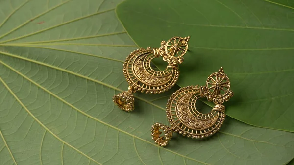 绿色叶子背景上的印度传统古董耳环或复古耳环 — 图库照片