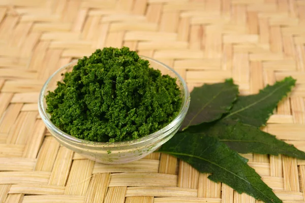 Tıbbi Ayurvedic Azadirachta indica veya Neem macunu ve ahşap arka planda yapraklar