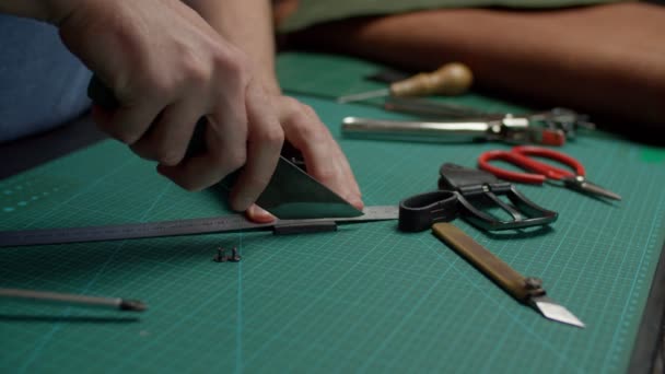 Kunstnijverheid met behulp van utility mes, afsnijden van riem lengte met de hand binnen — Stockvideo