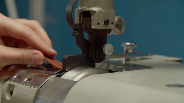 Craftsman using machinery, skiving leather piece indoors of workshop — Stock Video