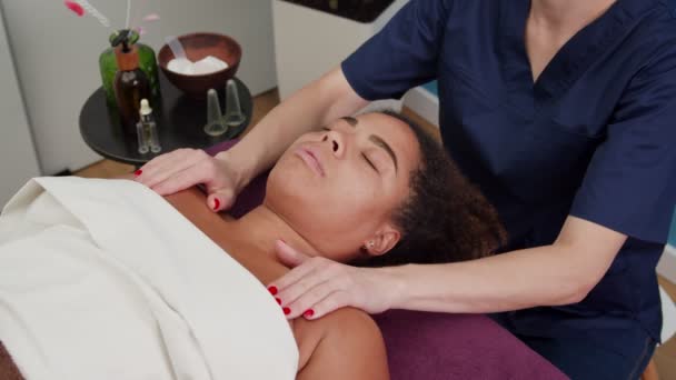 Massagista massageando peito e ombro de mulher atraente dentro de casa — Vídeo de Stock