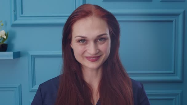 Retrato de mujer en uniforme médico sonriendo, guiñando un ojo, coqueteando un poco — Vídeo de stock