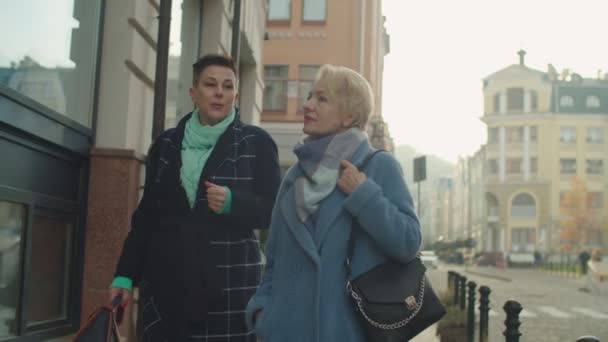 Starší ženy se dívají na výlohu obchodu venku, jdou nahoru po schodech obchod — Stock video
